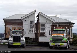 House cut in half on moving truck beds